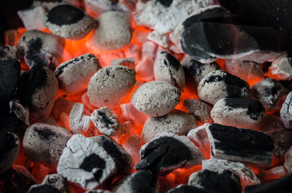 Starting a fire in a smoker grill with hot coals